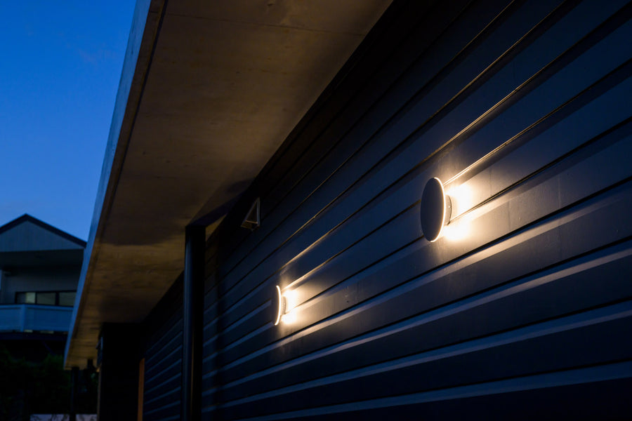 Havit Halo Black Round Wall Lights on a Dark Timber Clad Exterior at Dusk