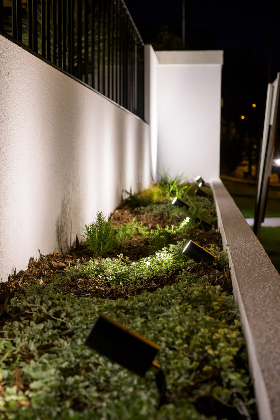 Havit Garden Spike Lights in a Raised Garden Bed Along a Rendered Boundary Wall
