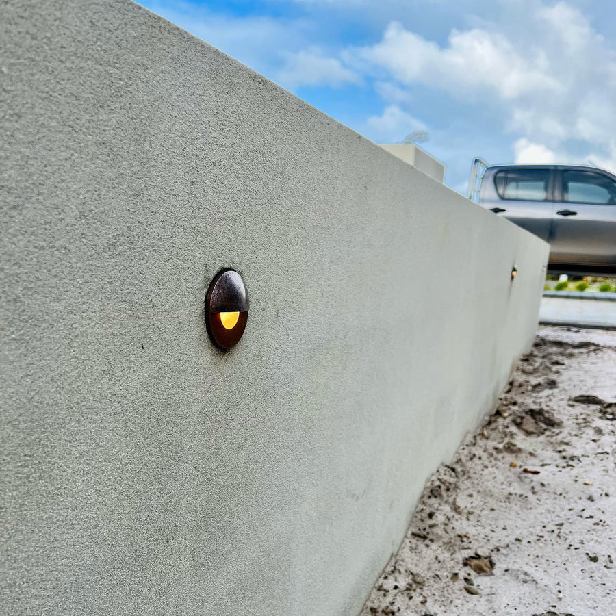 Ollo Antique Brass Step Lights Along Rendered Boundary Wall