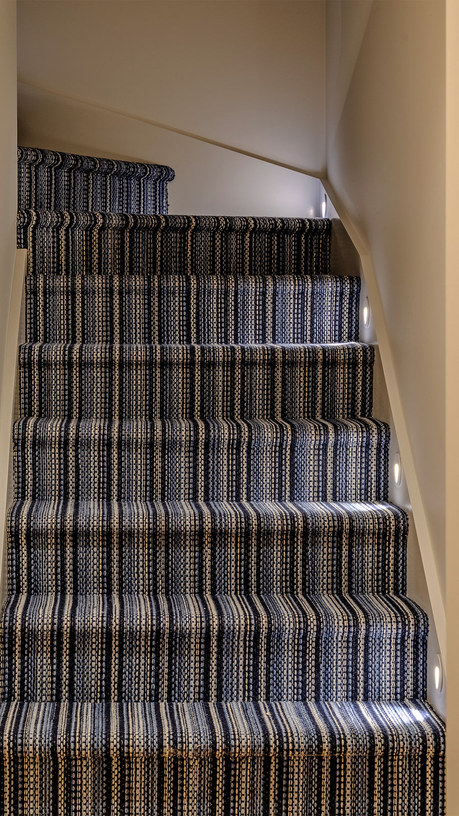Mini Reces White Step Lights Along Indoor Carpeted Staircase