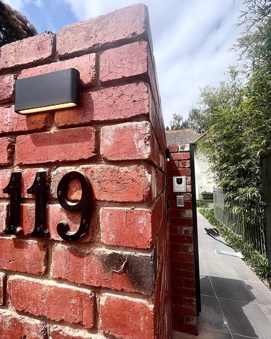 Lisse Black Fixed Down Wall Light Above Brick House Number