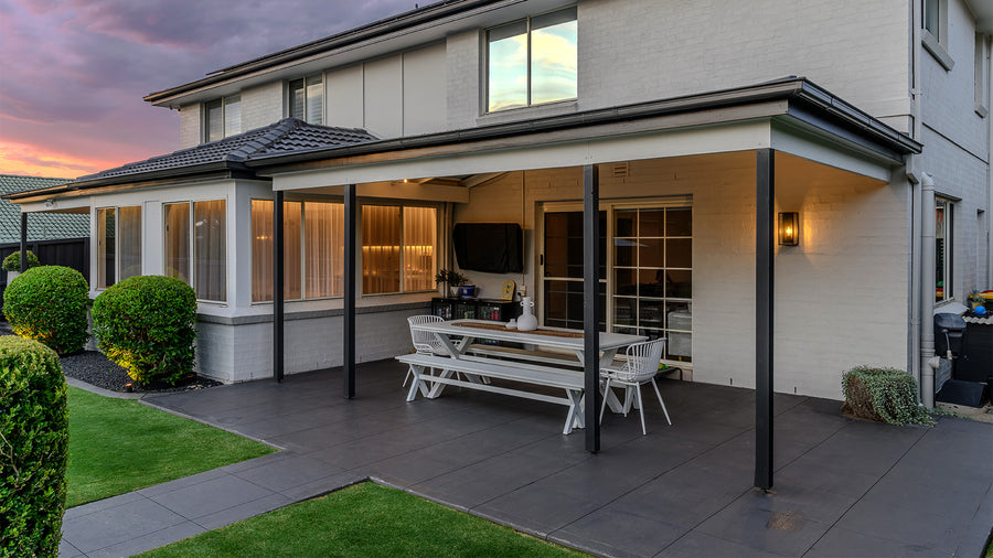 Black Exterior Bayside Wall Light Beside Covered Outdoor Patio