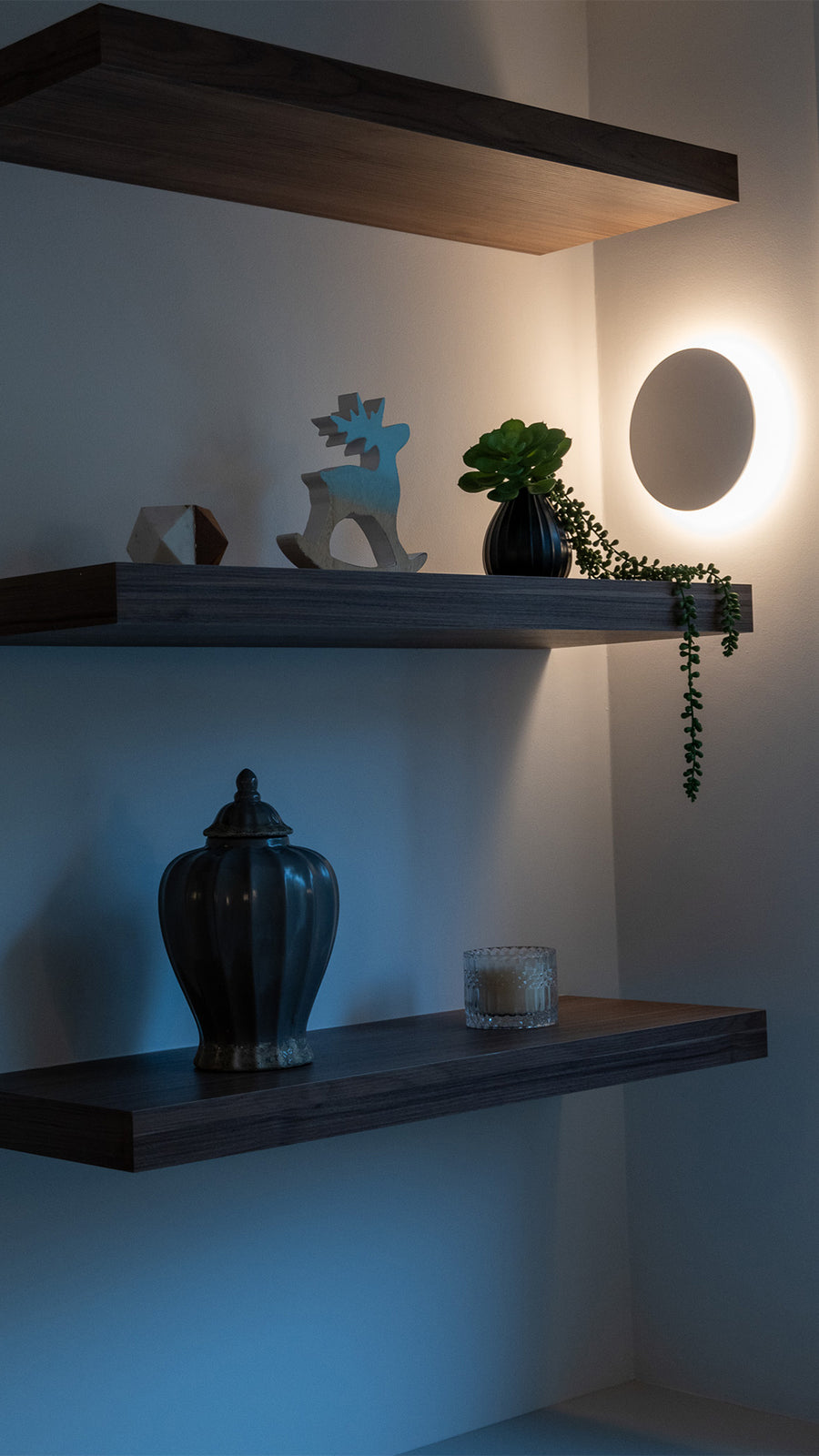 Havit Halo White Round Wall Light Glowing Between Floating Shelves in a Living Room