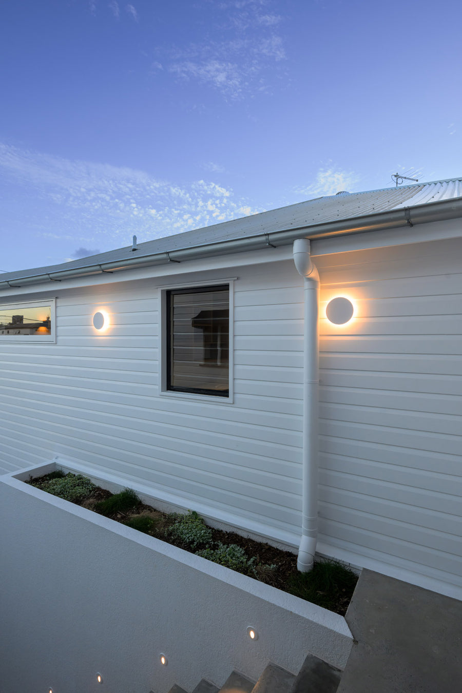 Havit Halo White Wall Lights and Recessed Step Lights on a Weatherboard Home Exterior at Dusk