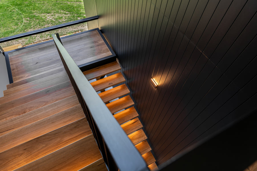 Lisse Black Up and Down Wall Light Beside Timber Staircase